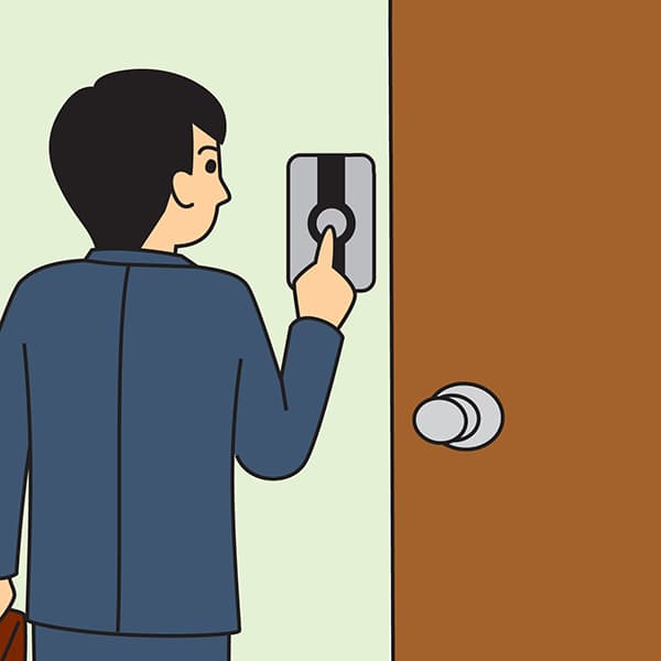 玄関ボタンを押すスーツ姿の男性