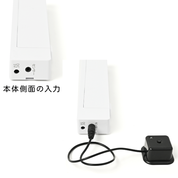 光センサー送信機本体の側面にある入力端子の写真。DC 5V（電源アダプタ用）とセンサー（光センサー用）の2つの入力ジャックがあり、下の写真では光センサーのケーブルが「センサー」の端子に接続されています。