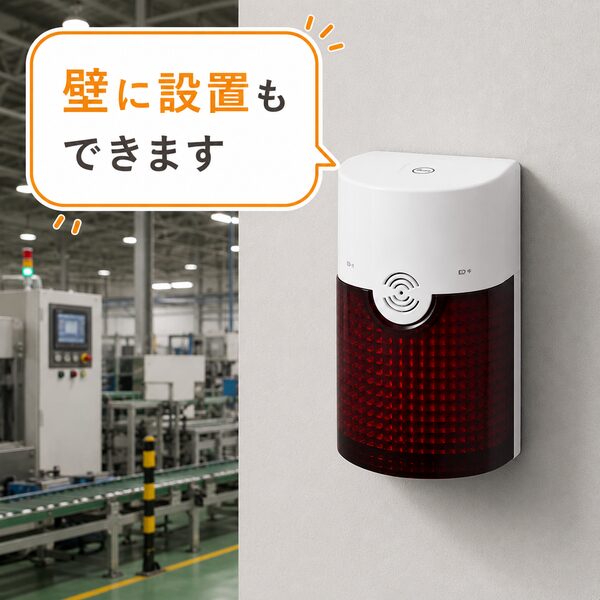工場の壁にフラッシュチャイムを設置しているイメージ。機械のある作業現場でも壁に固定して利用できることを紹介したイラスト。吹き出しには「壁に設置もできます」と表示されている。