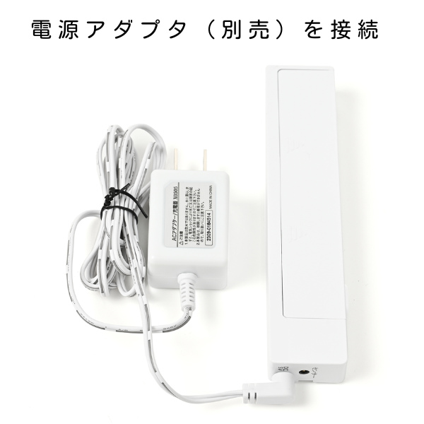 白い電子機器の本体に、別売りのACアダプター（充電器）の給電ケーブルを接続した使用方法の説明